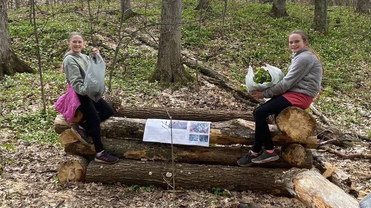 a couple of young female volunteers resting during our 2021 garlic mustard clean-up